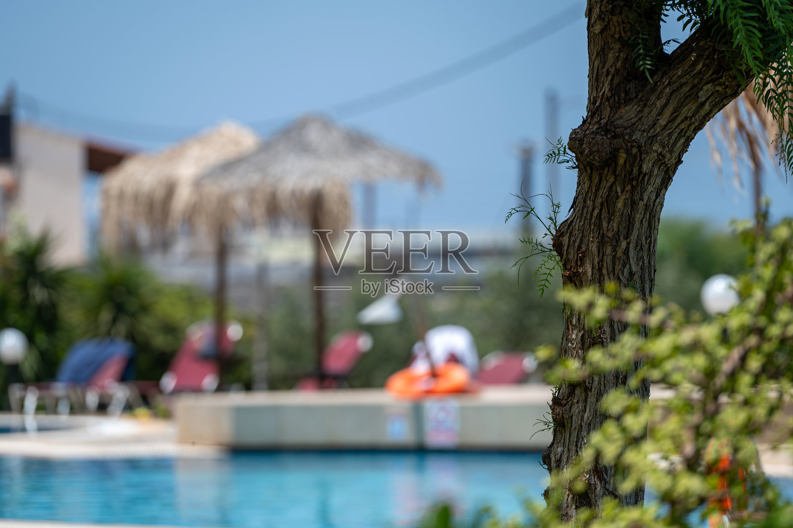 在阳光明媚的日子里,悠闲地在克里特岛的宁静泳池旁放松照片摄影图片