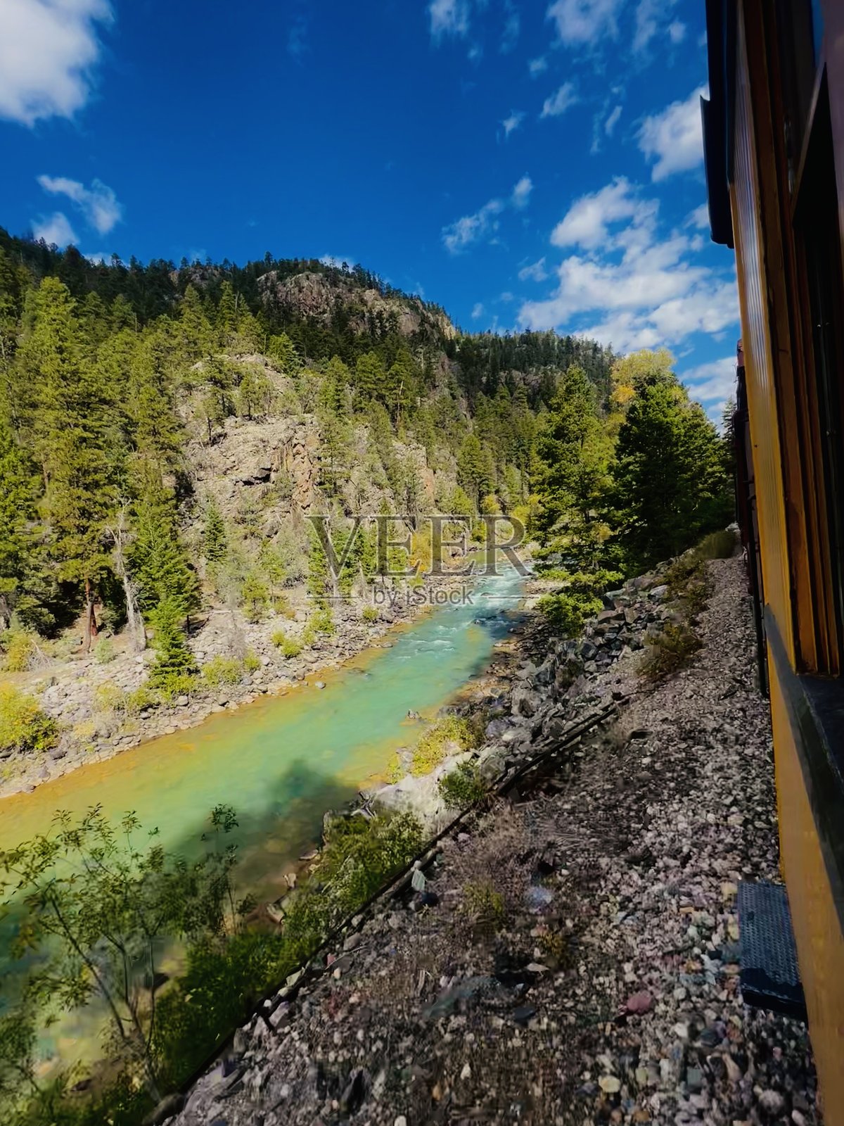 从复古火车窗户俯瞰科罗拉多州的碧绿色水域和老旧铁路照片摄影图片