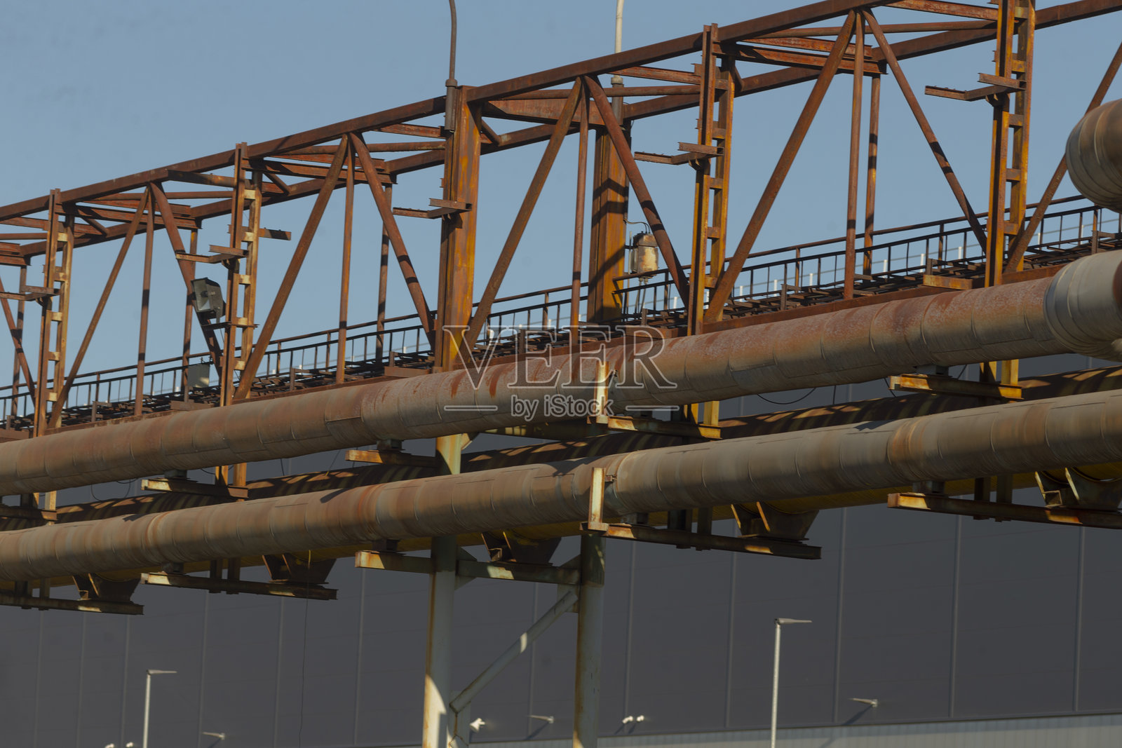 有一座桥,上面有许多管道延伸而过。照片摄影图片