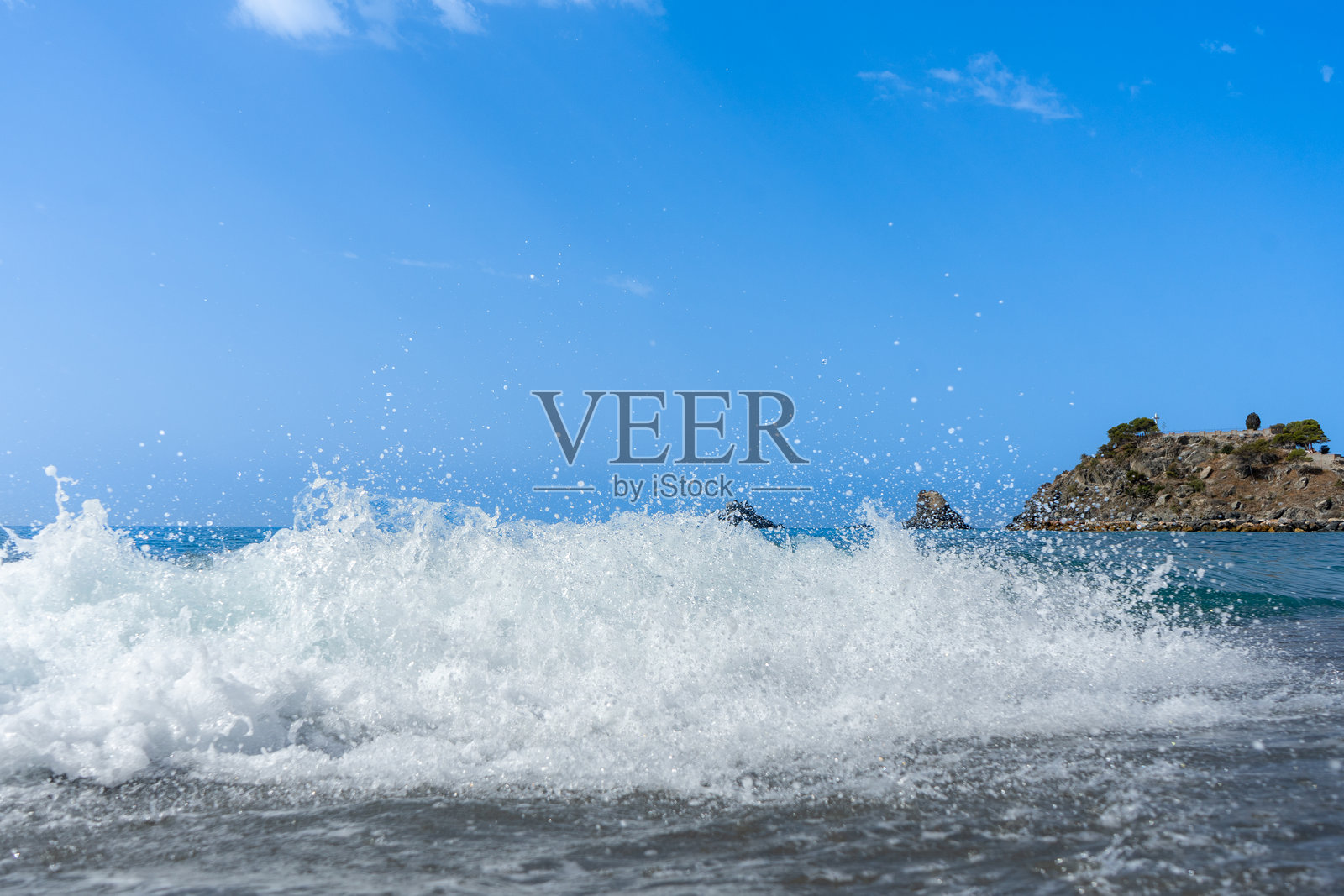 海浪拍打着海岸,溅起泡沫。照片摄影图片