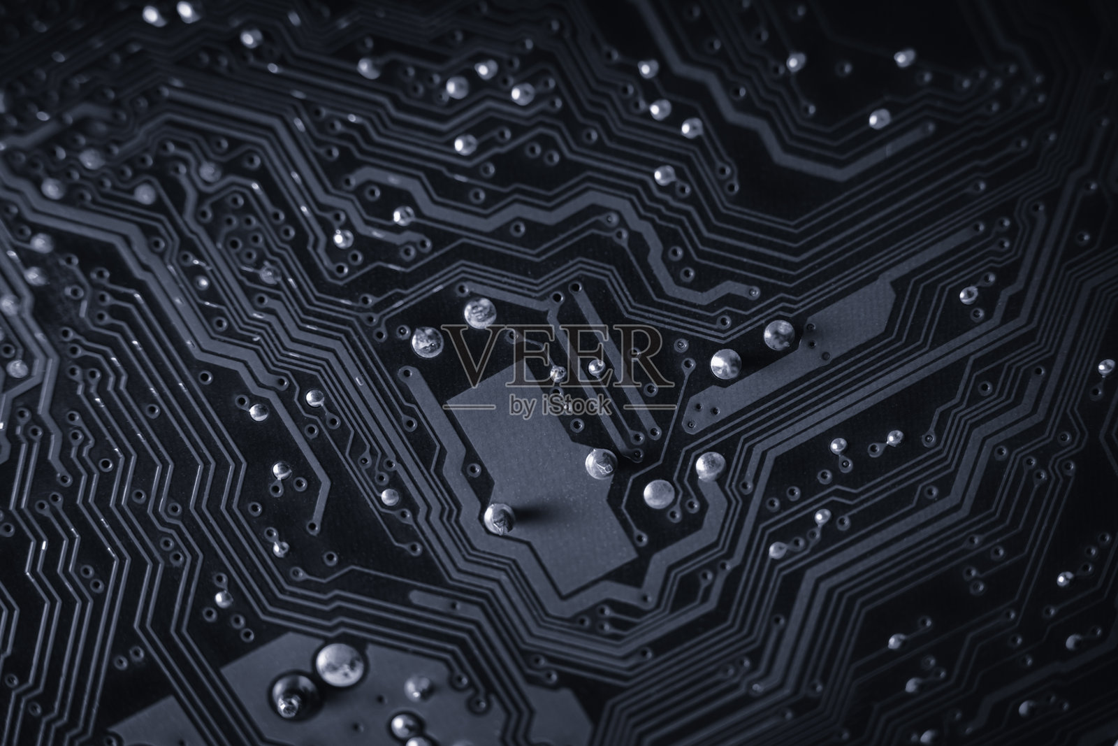 电子电路板的特写,水滴突显出复杂的路径和连接。照片摄影图片