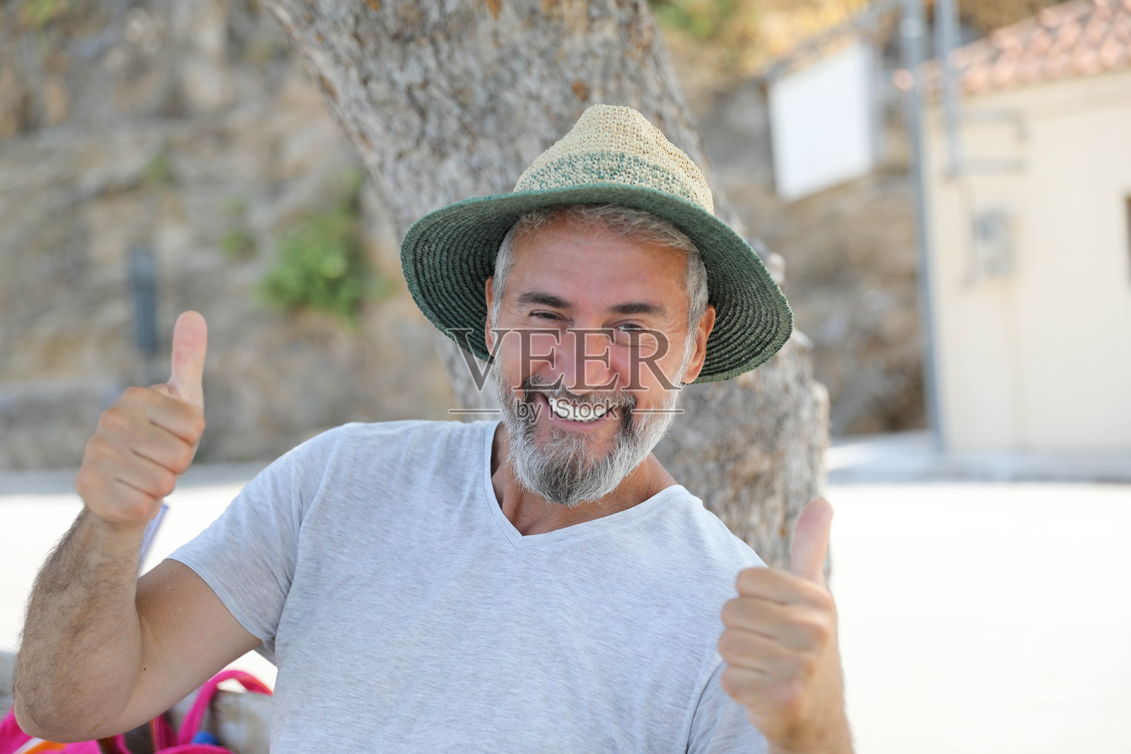 快乐的老年男子在户外放松,戴着夏季帽子照片摄影图片