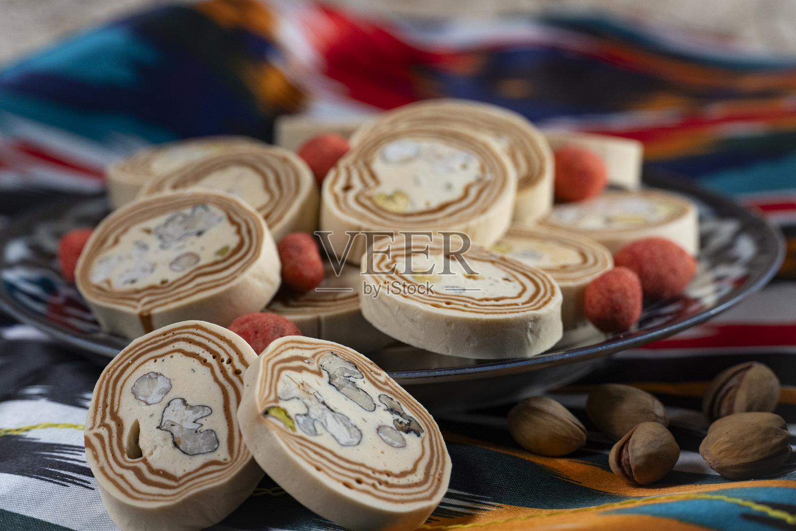 乌兹别克盘子上的开心果哈瓦和辣味花生照片摄影图片