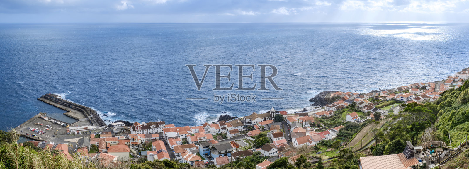 亚速尔群岛圣乔治岛的全景卡尔赫塔村,传统红瓦屋顶与大西洋美景。葡萄牙沿海小镇,火山岛建筑,海洋遗产。照片摄影图片