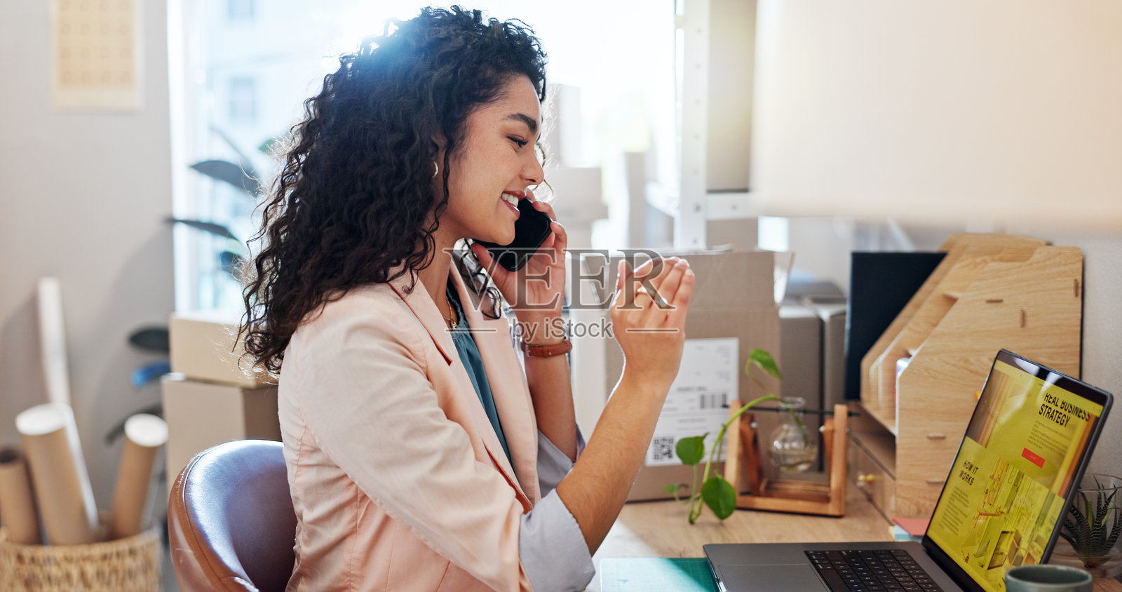 女性在小型企业中通过笔记本电脑或电话进行订单,涉及库存、供应链或时尚精品店的创业。设计师、店主与在线货运、销售服务和电子商务配送进行沟通。照片摄影图片