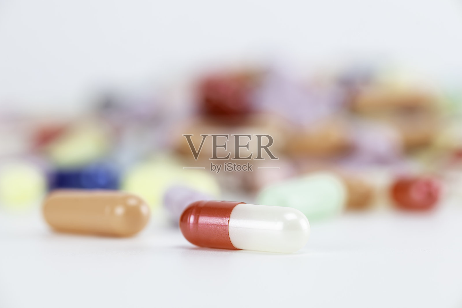 一颗红白相间的药丸,清晰聚焦,代表着重要的药物剂量。这些医疗胶囊对于治疗至关重要,由药店开处方以促进健康和福祉。照片摄影图片