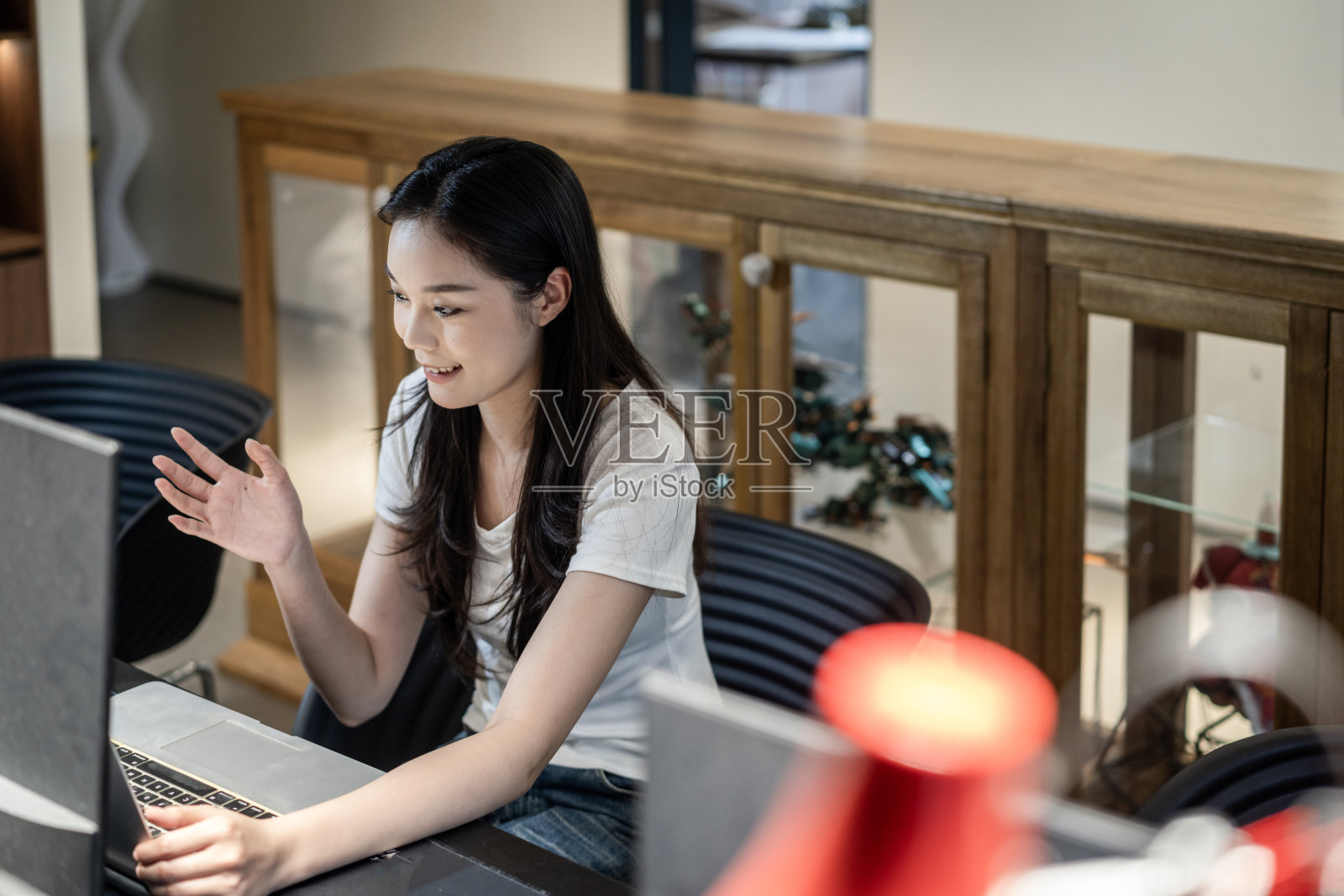 一位年轻的中国女性正在办公室工作。照片摄影图片