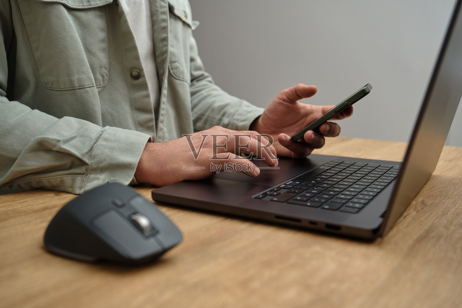 男人在木桌上使用笔记本电脑和手机的特写图像,商业概念。照片摄影图片