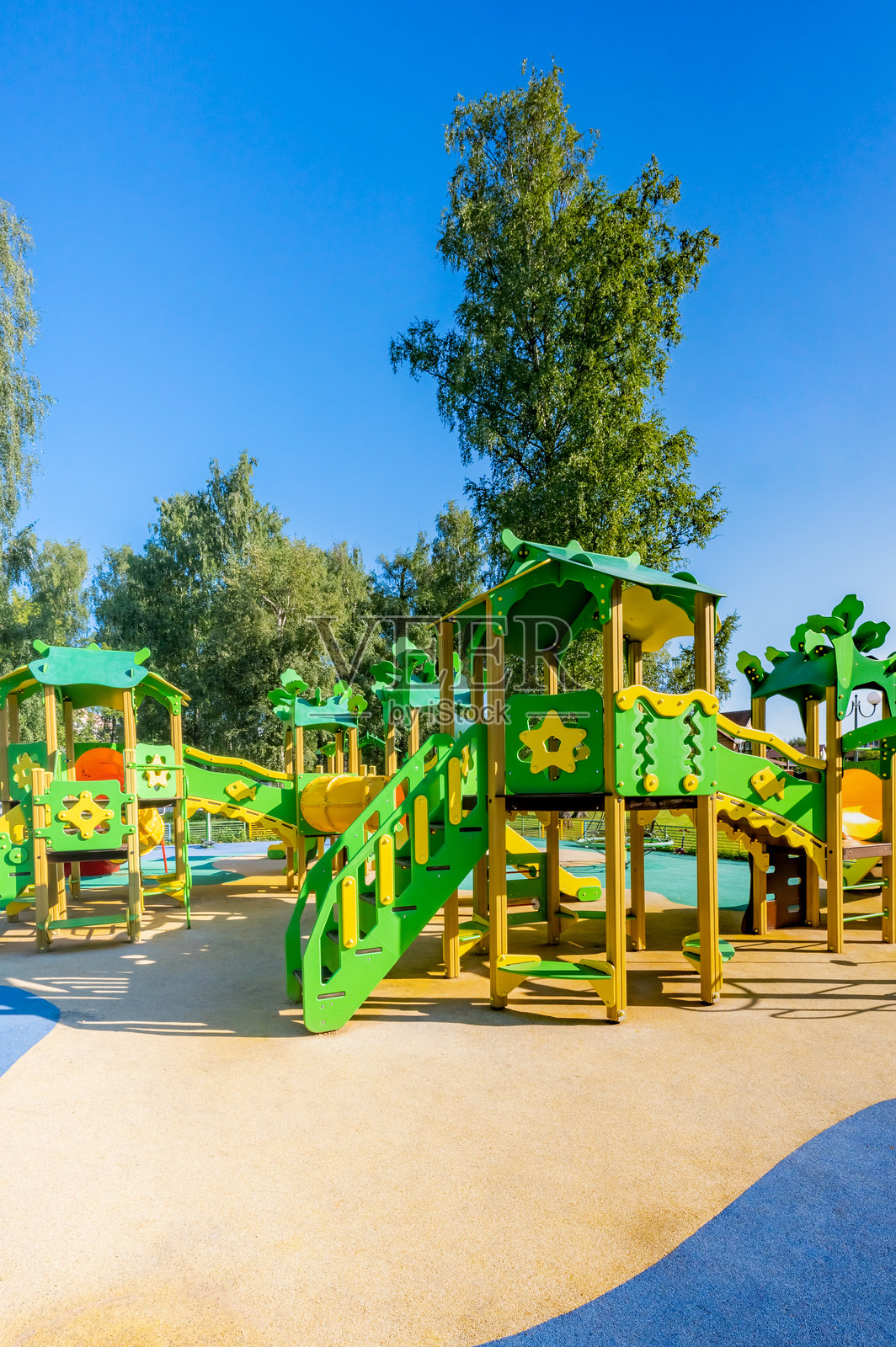 有黄色围栏和绿色游乐设施的游乐场照片摄影图片