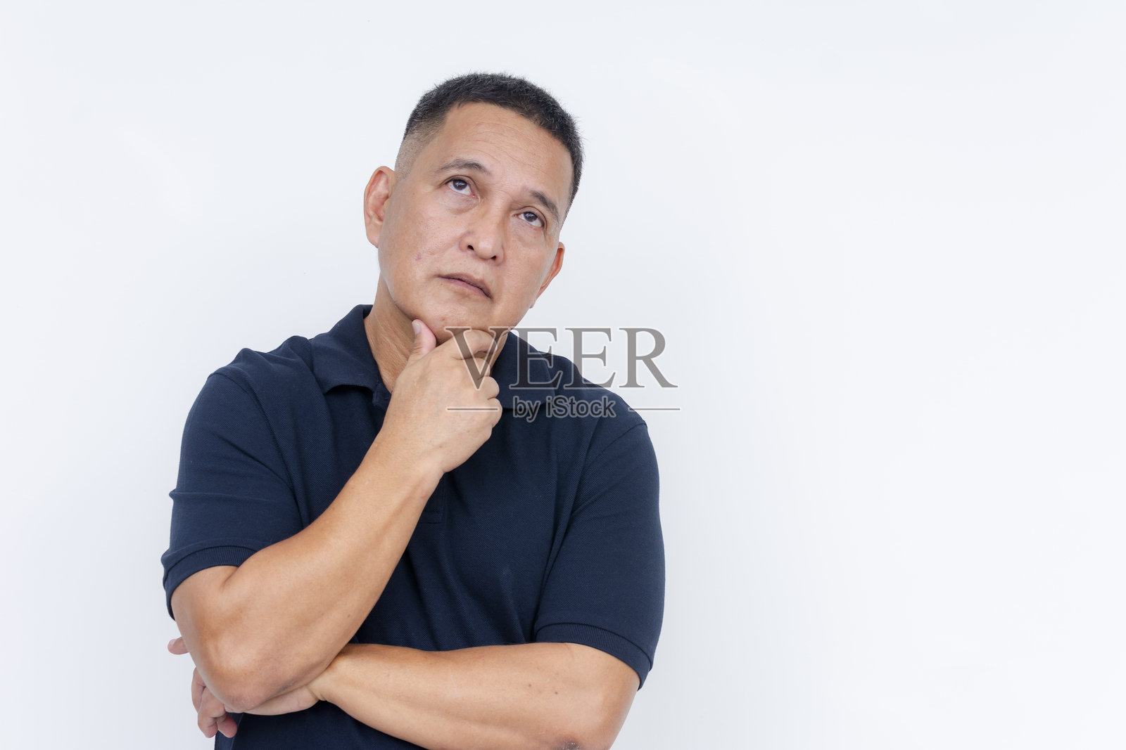 一位沉思的中年亚洲男性,手托下巴,仰望着天空,背景为白色,正在思考。照片摄影图片
