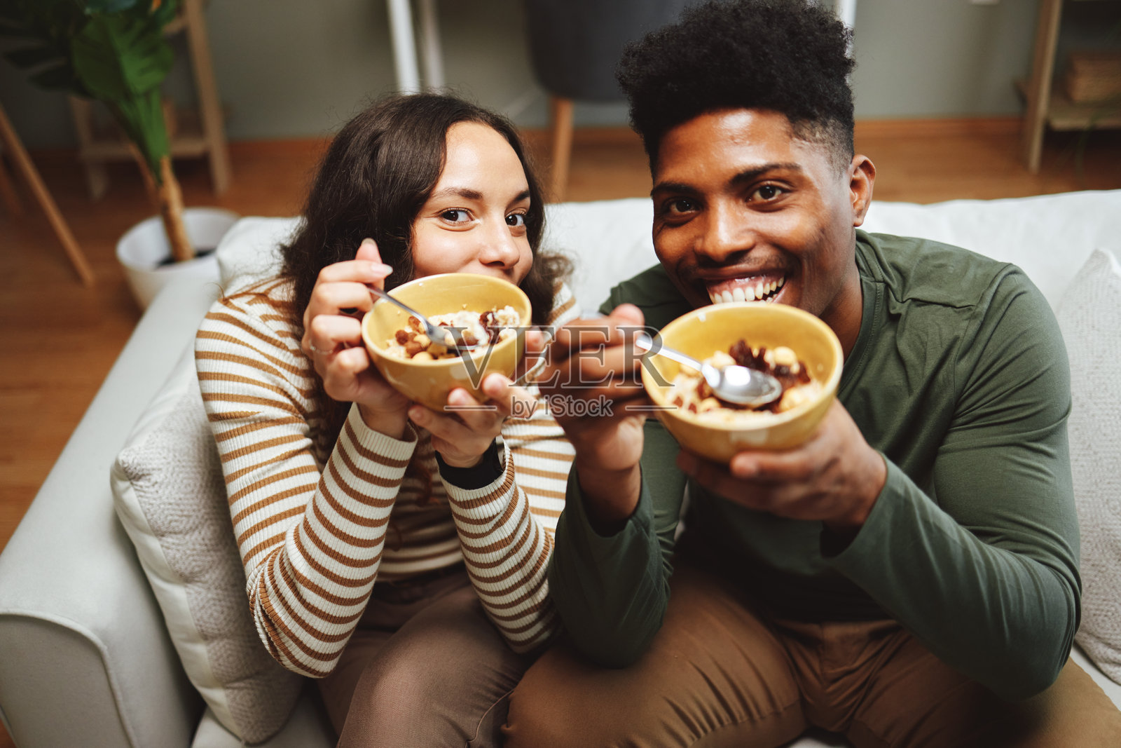 快乐的情侣在沙发上一起享用早餐麦片照片摄影图片
