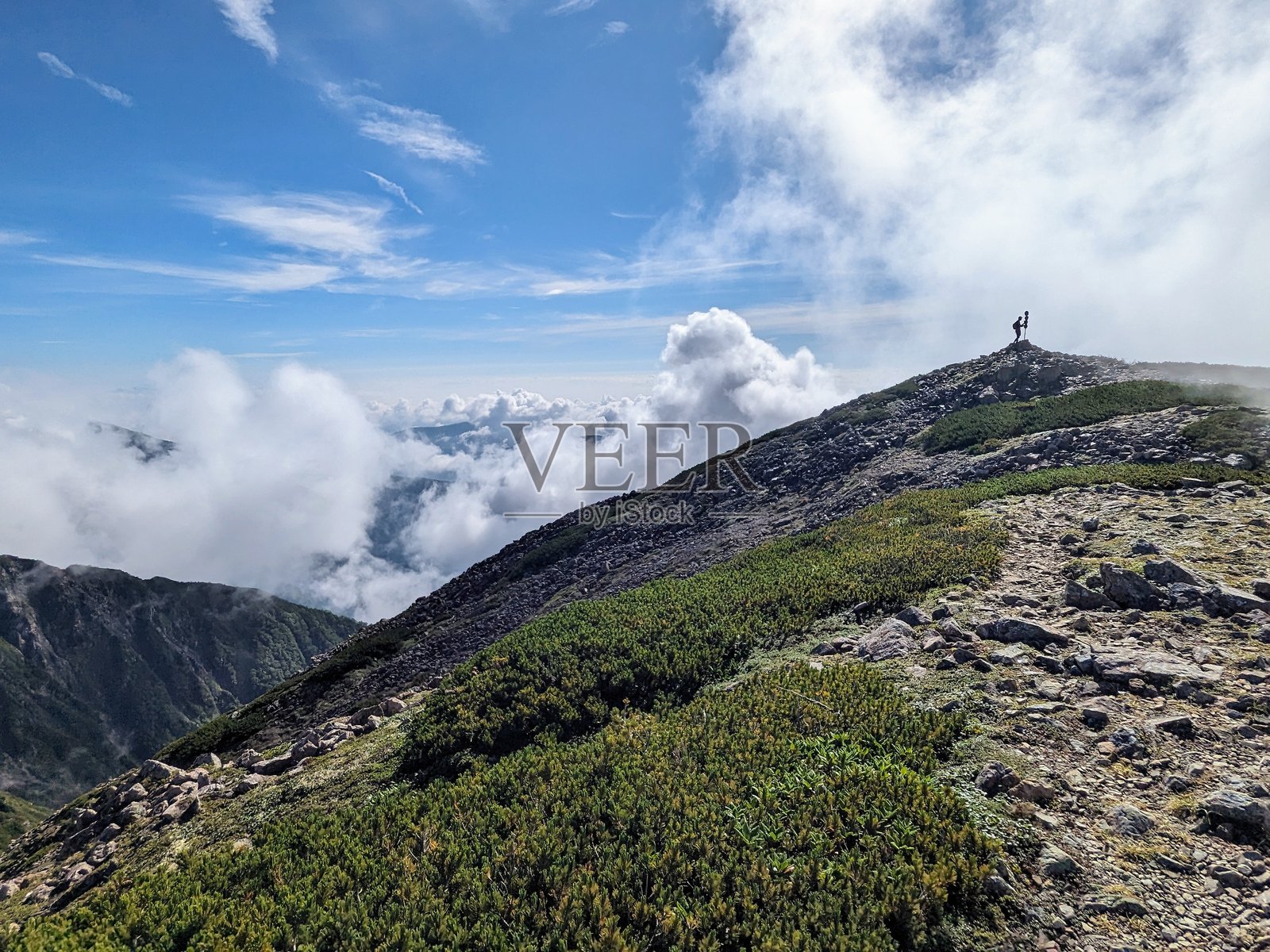 八月,云层接近日本静冈县静冈市的赤石岳山顶。照片摄影图片