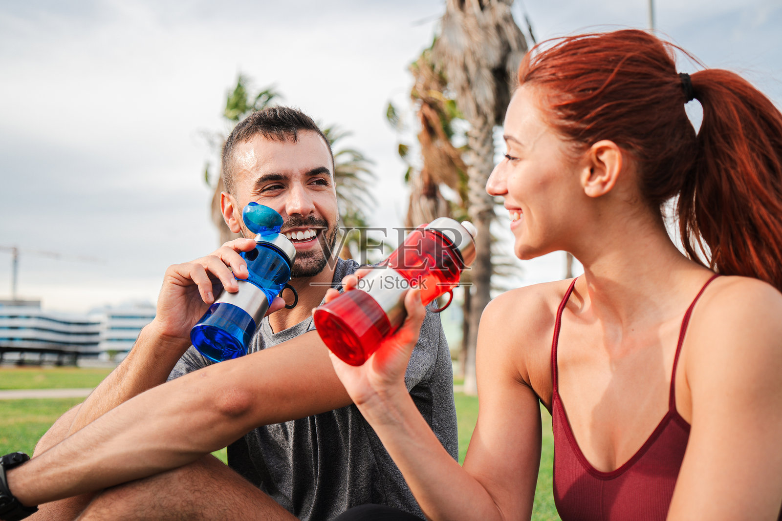 活力四射的运动情侣在明亮活泼的公园中休息,享受清爽的水瓶,作为锻炼后的放松,健康与健身训练爱好者。照片摄影图片