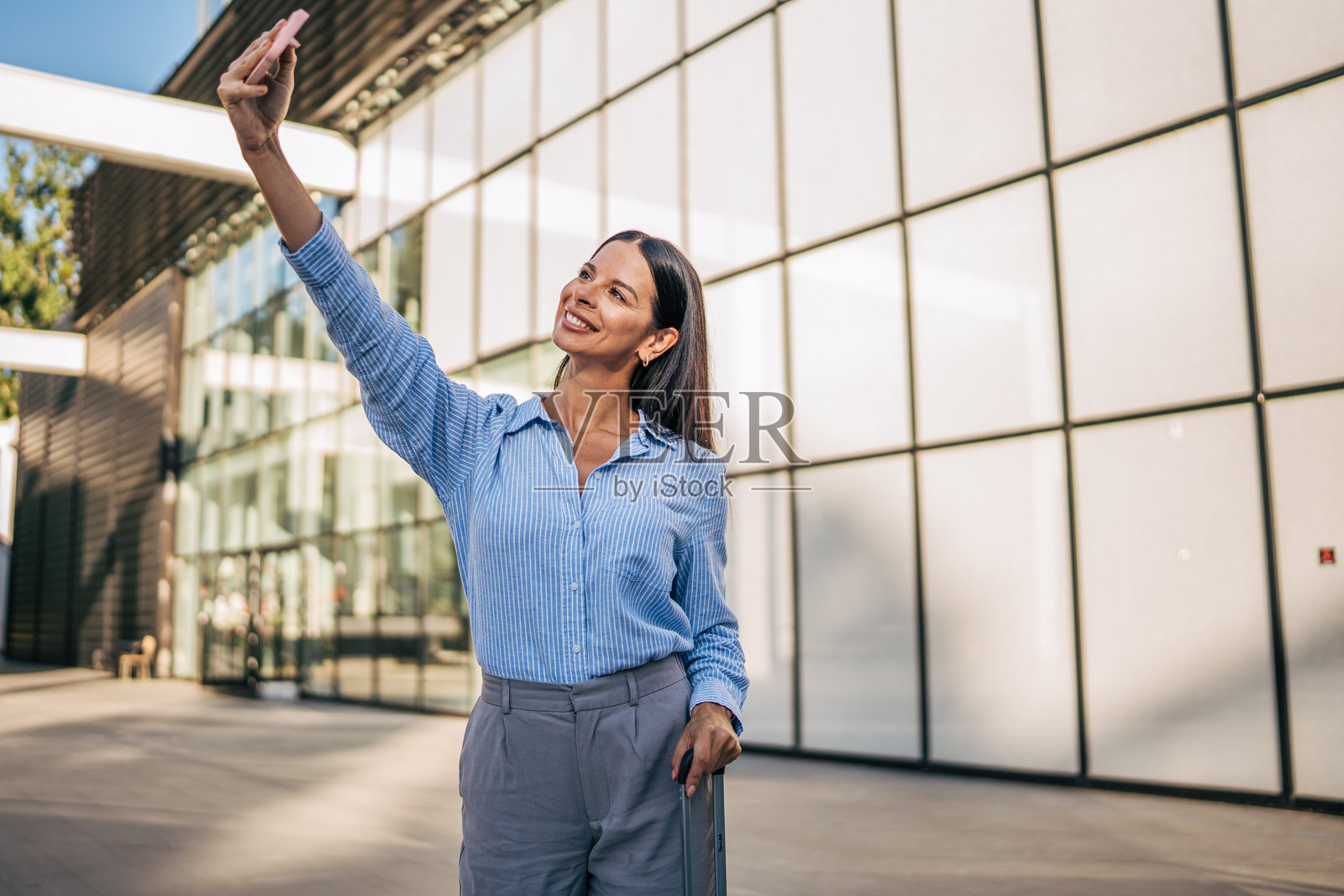 在现代建筑外自拍的女商人照片摄影图片