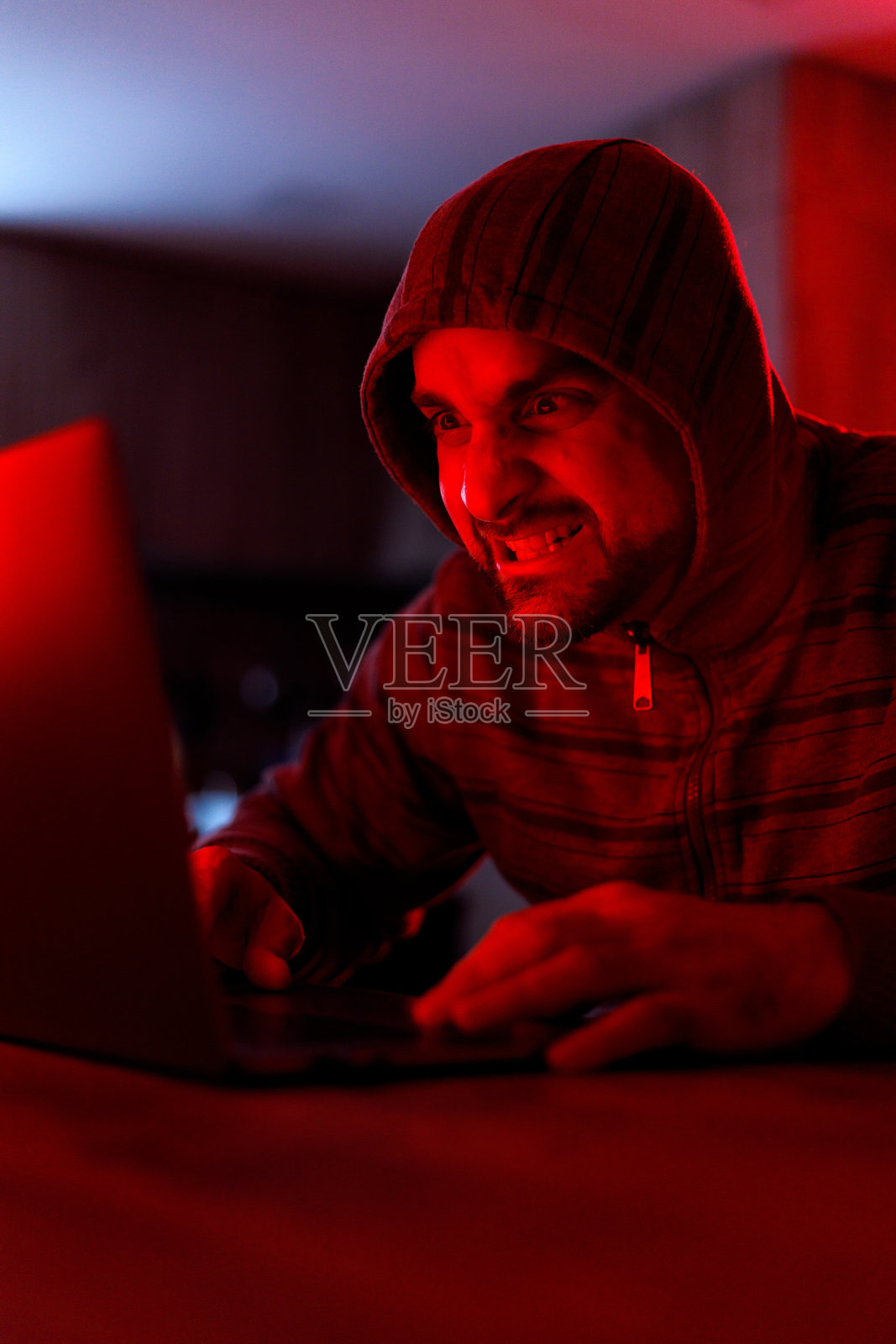 在昏暗的房间里,专注的黑客熬夜工作照片摄影图片