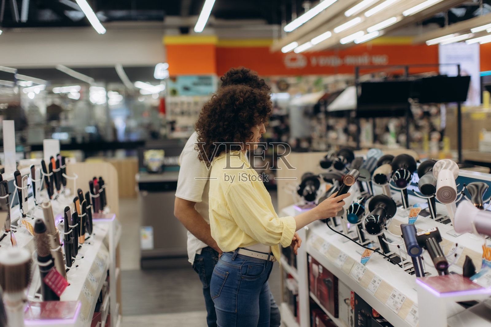 情侣在电子商店购物,挑选吹风机照片摄影图片