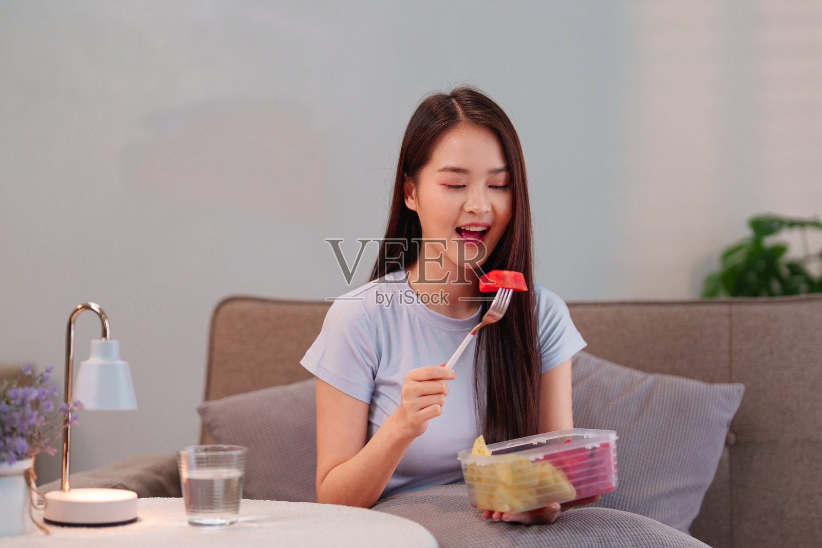 年轻亚洲女性享受健康水果零食,追求长寿生活方式,快乐健康饮食,良好的生活习惯。照片摄影图片