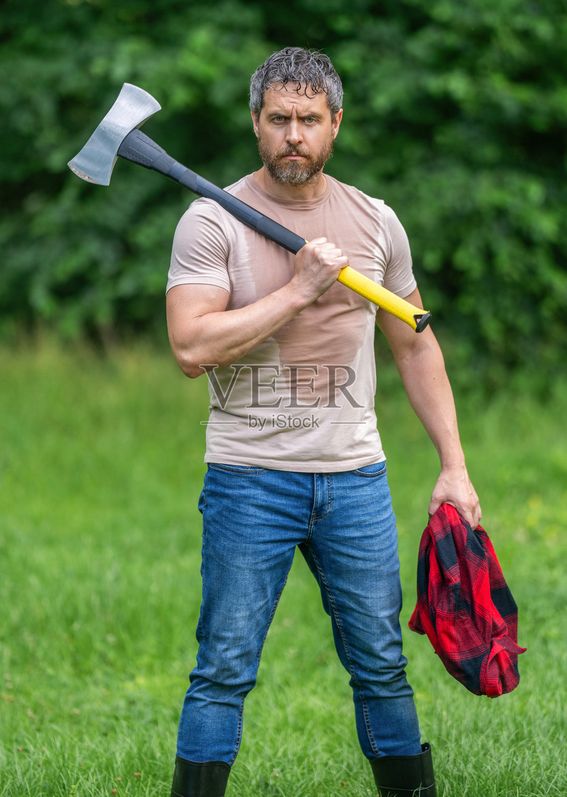 森林中的伐木工人手持斧头。伐木工人背着斧头。森林的宁静。帅气的男人手持斧头。伐木工人在树林中挥舞斧头。穿着衬衫的伐木工人手握重斧。强壮的男人在森林中工作。照片摄影图片