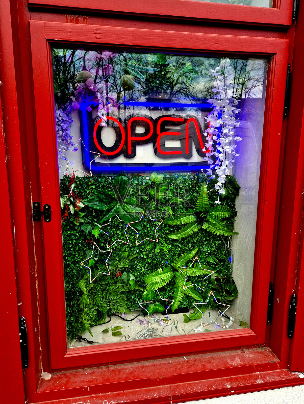 消防车间的广告牌打开了。背景由塑料植物组成。观赏静物广告横幅园艺店橱窗、画框照片摄影图片