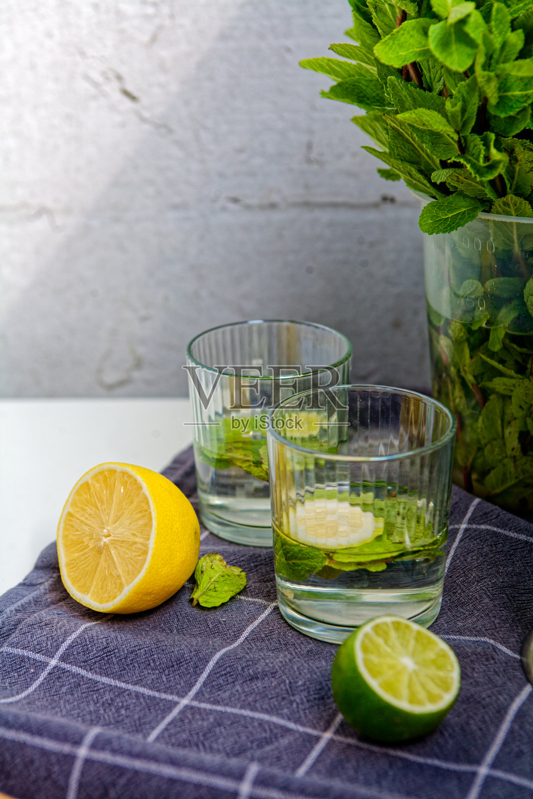 清爽的夏季饮品准备,配有柠檬、青柠和薄荷叶,放在木板上。照片摄影图片