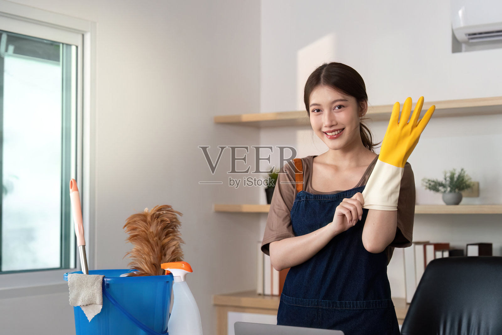 家庭清洁。准备戴上手套和工具进行清洁的人。照片摄影图片