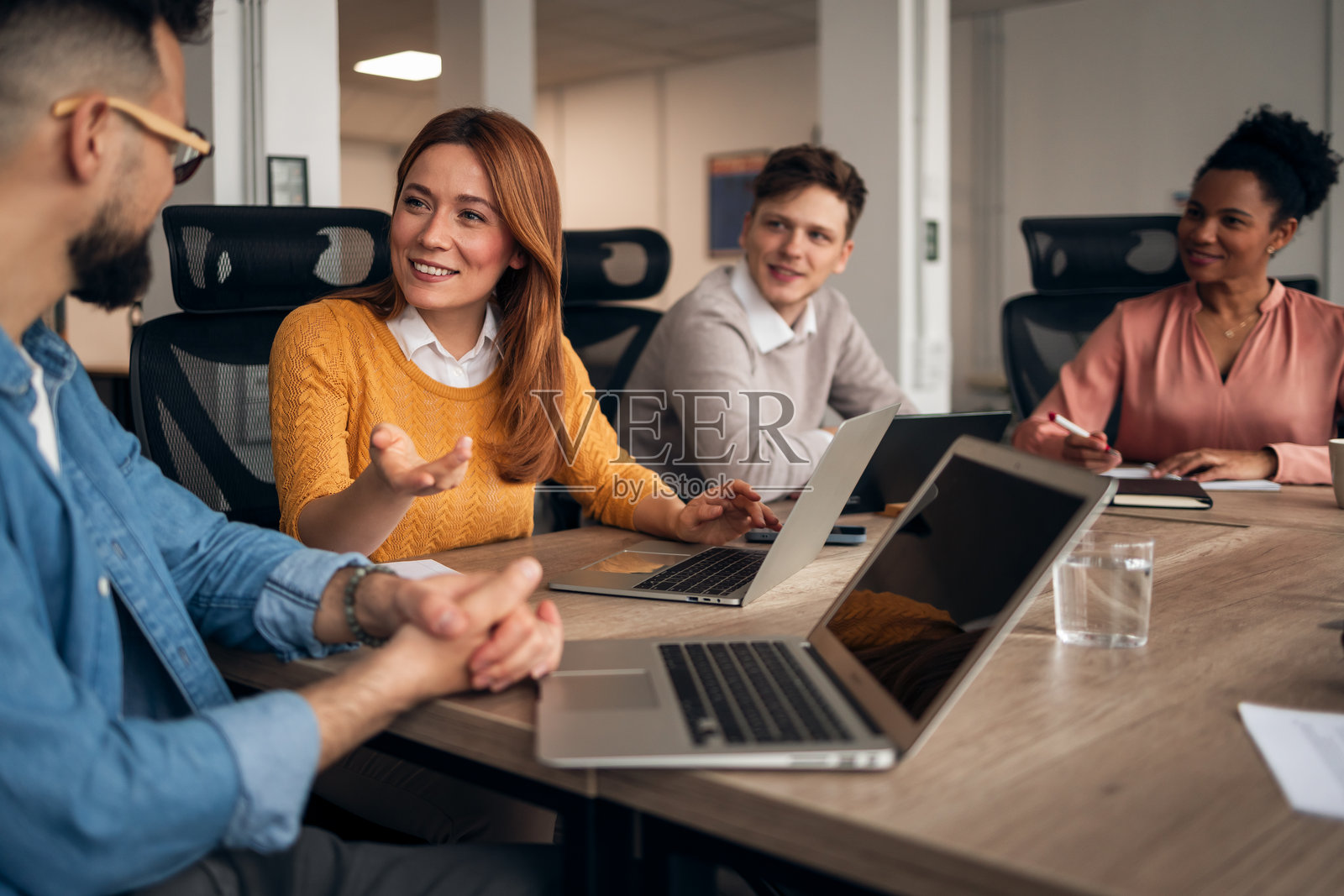 同事们在现代办公室环境中围绕电脑进行协作照片摄影图片