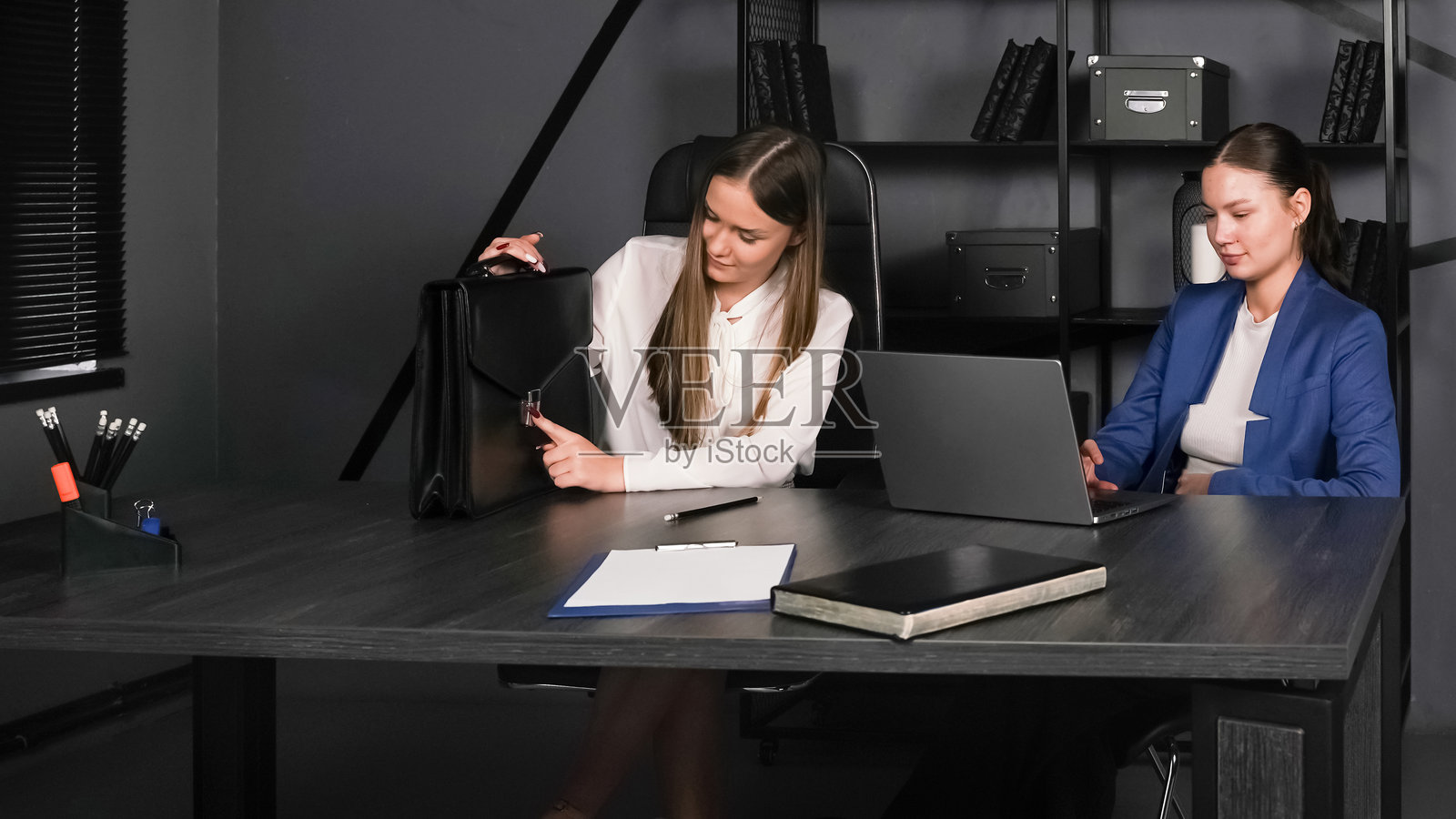 两位女性在现代办公室环境中白天讨论策略照片摄影图片