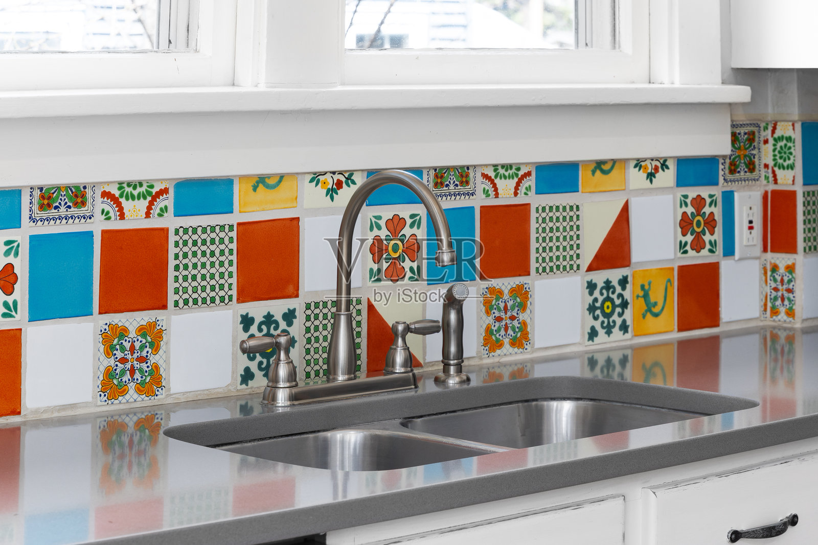 带有彩色瓷砖背墙的厨房水槽细节。照片摄影图片