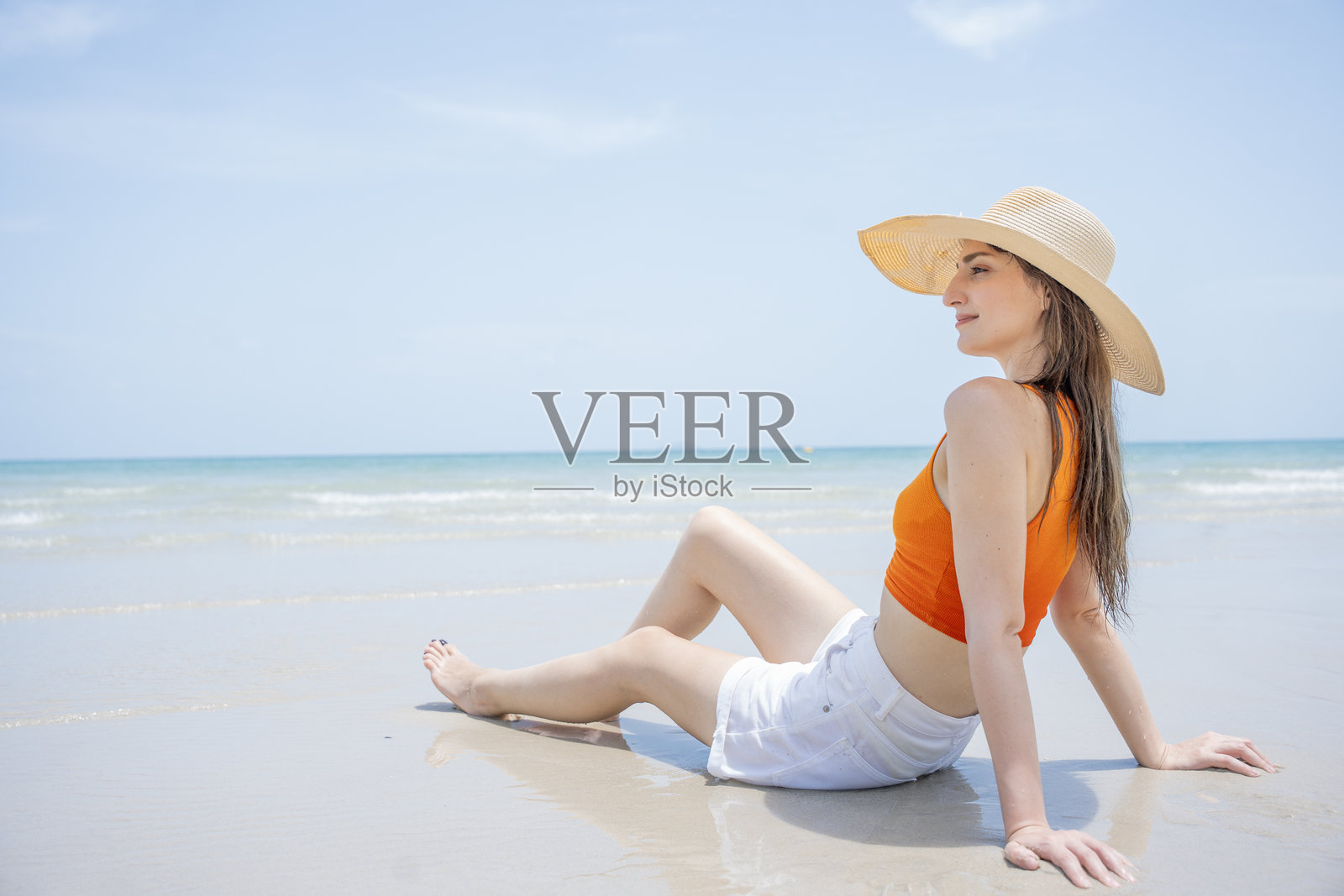 美丽性感的女人在海滩上,背景是大海。照片摄影图片