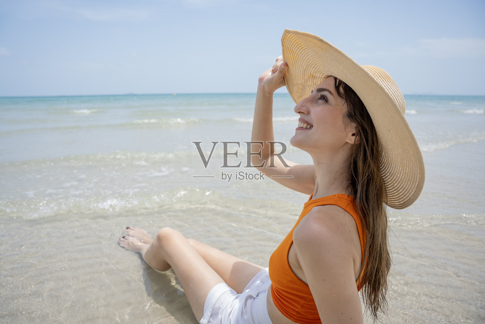 美丽性感的女人在海滩上,背景是大海。照片摄影图片