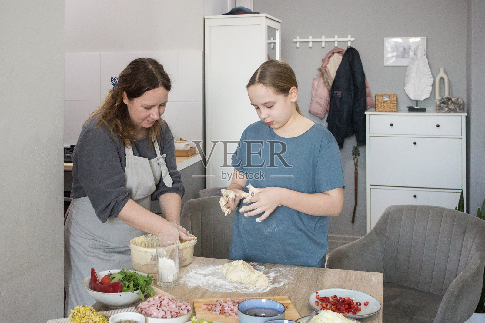 母亲和孩子们在家厨房里一起做披萨照片摄影图片