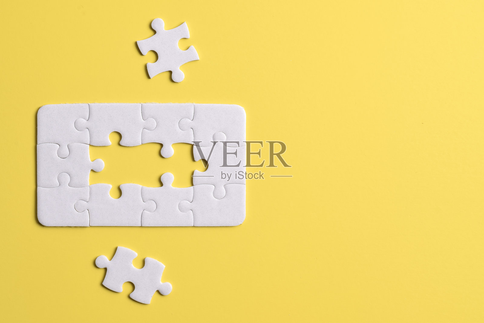黄色背景上的白色拼图块照片摄影图片
