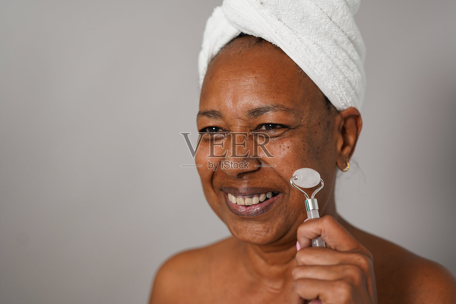 快乐的非洲老年女性正在进行护肤程序 - 老年人,健康与面部美容护理概念照片摄影图片