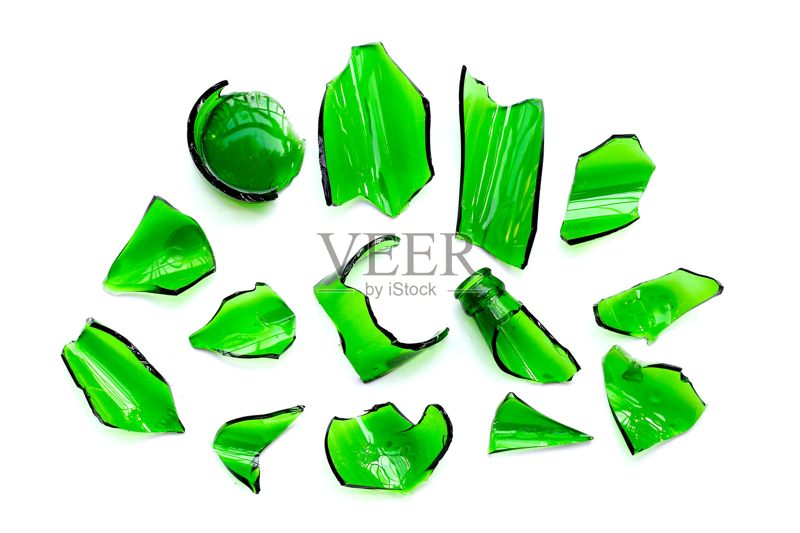 锋利的绿色玻璃碎片散落在白色背景上。照片摄影图片