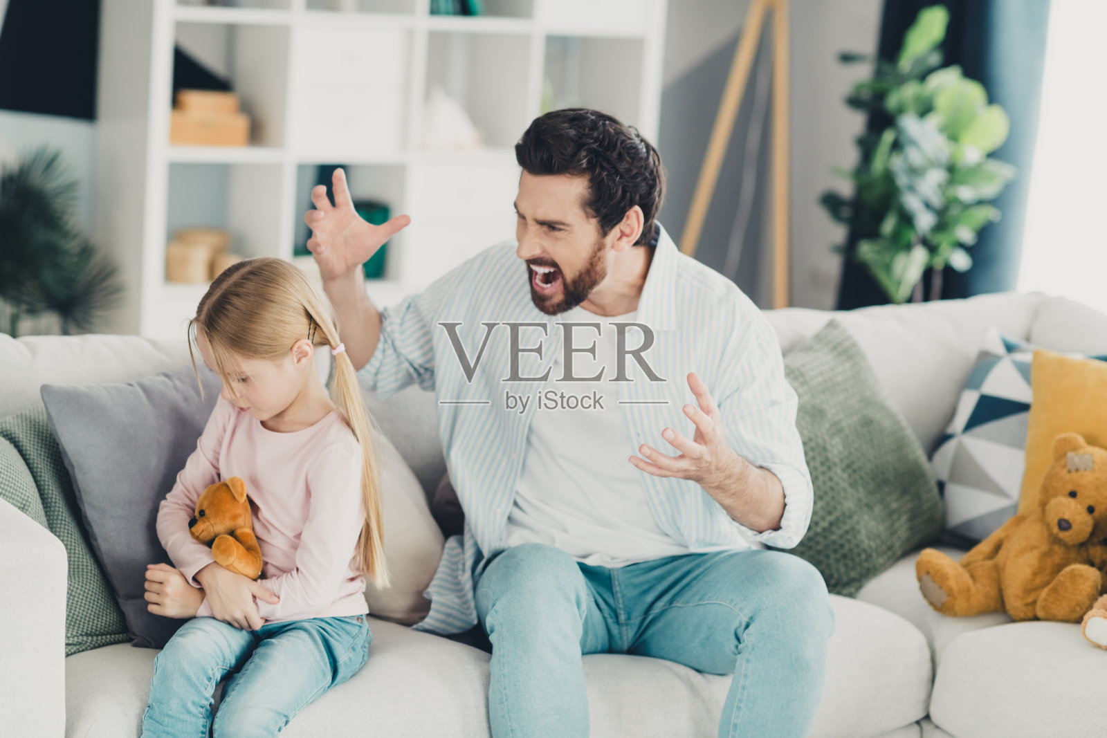 愤怒的父亲与年轻女儿在家中分享紧张时刻,突显情感纽带和关系照片摄影图片