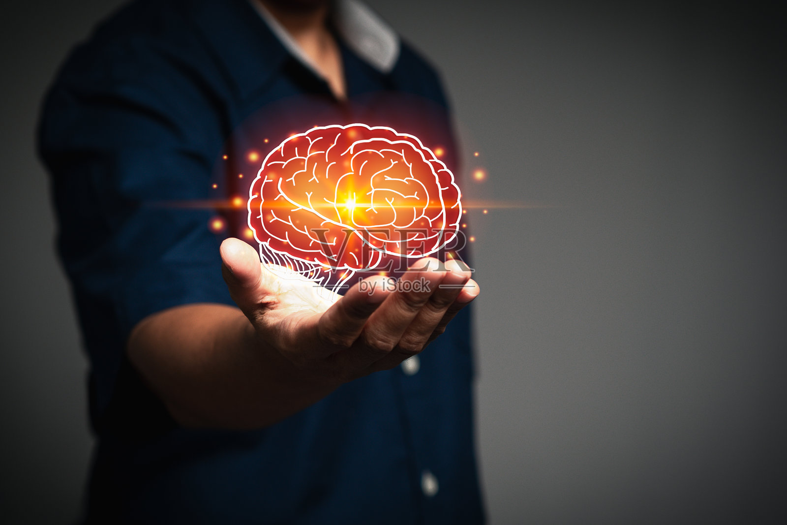 手中握着的未来派大脑全息图,突显创造力、知识和科技。照片摄影图片