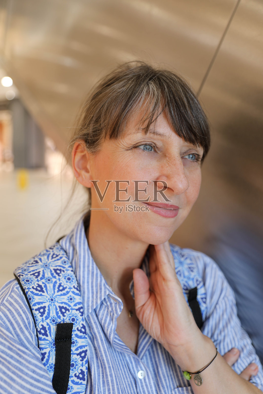 优雅的50岁以上女性在商店内使用扶梯购物照片摄影图片