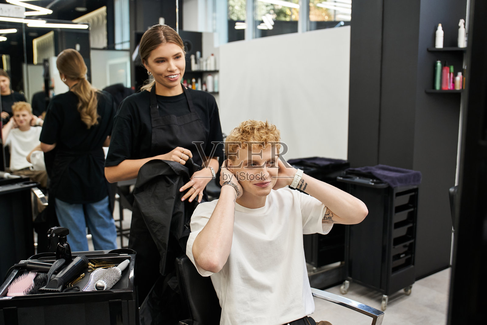 在时尚美容院中,才华横溢的造型师为满意的客户打造新造型照片摄影图片