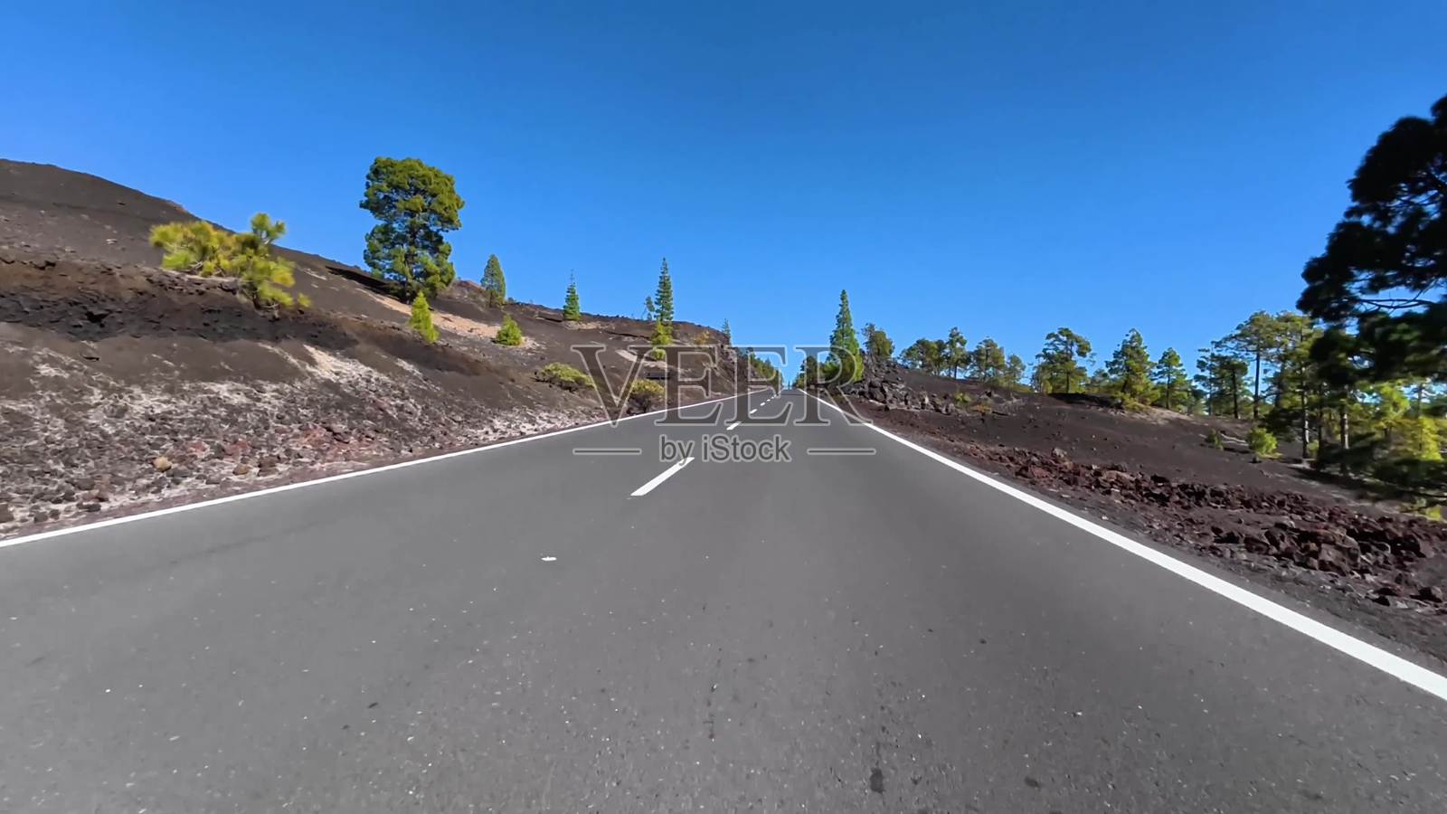 一条风景如画的山路,展现出在晴朗蓝天下的壮丽火山景观照片摄影图片