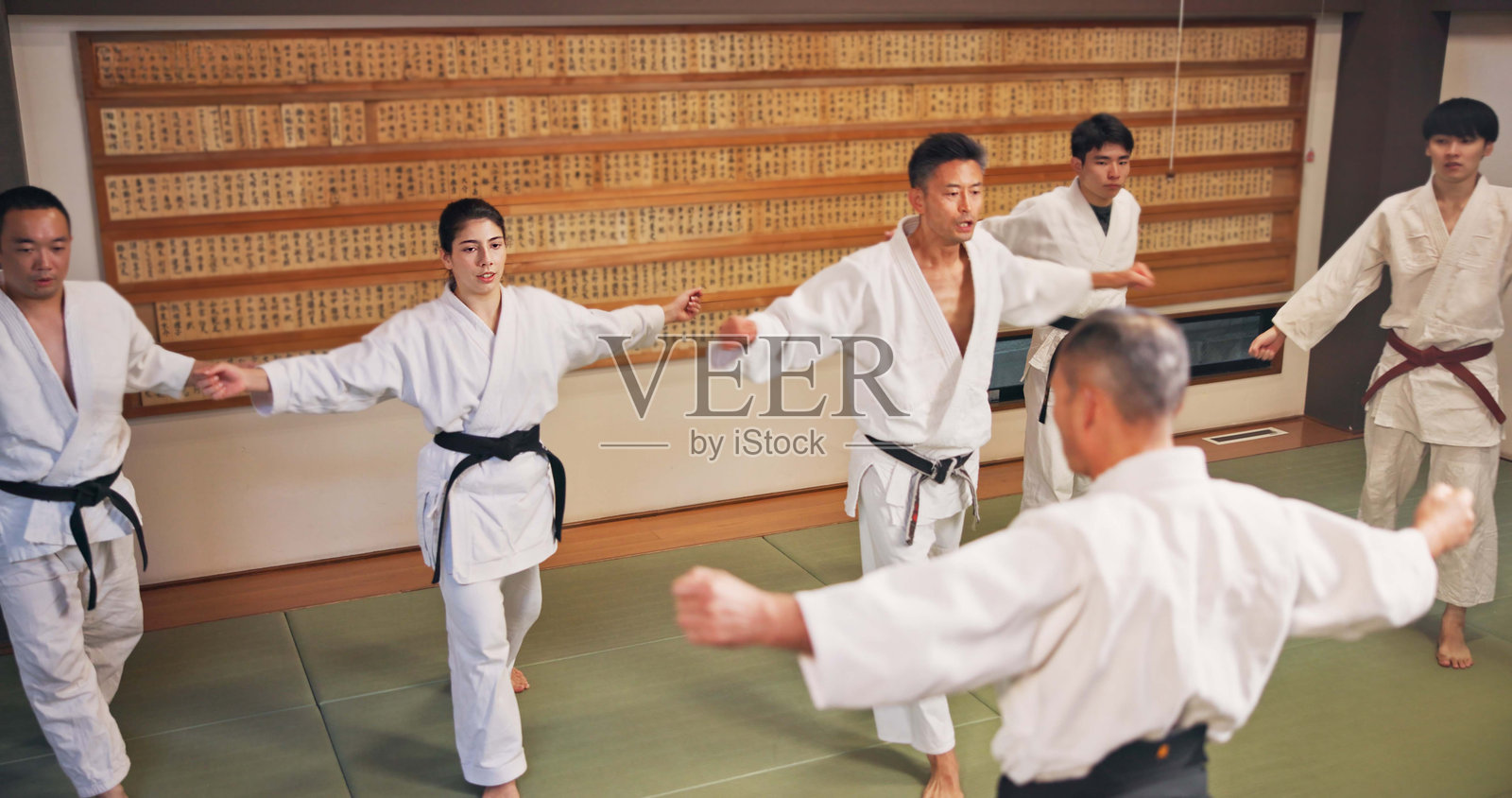 武术,师傅和日本人在道场学习、锻炼和练习空手道礼仪。日本,战斗训练和健身房的搏击工作室,武术、纪律和武士在跆拳道课程中。照片摄影图片