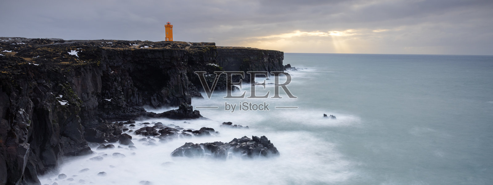 基尔基尤山在明亮的蓝天映衬下雄伟耸立,瀑布倾泻而下,流入宁静的河流。这幅令人惊叹的冰岛风景展现了大自然的壮丽之美。照片摄影图片