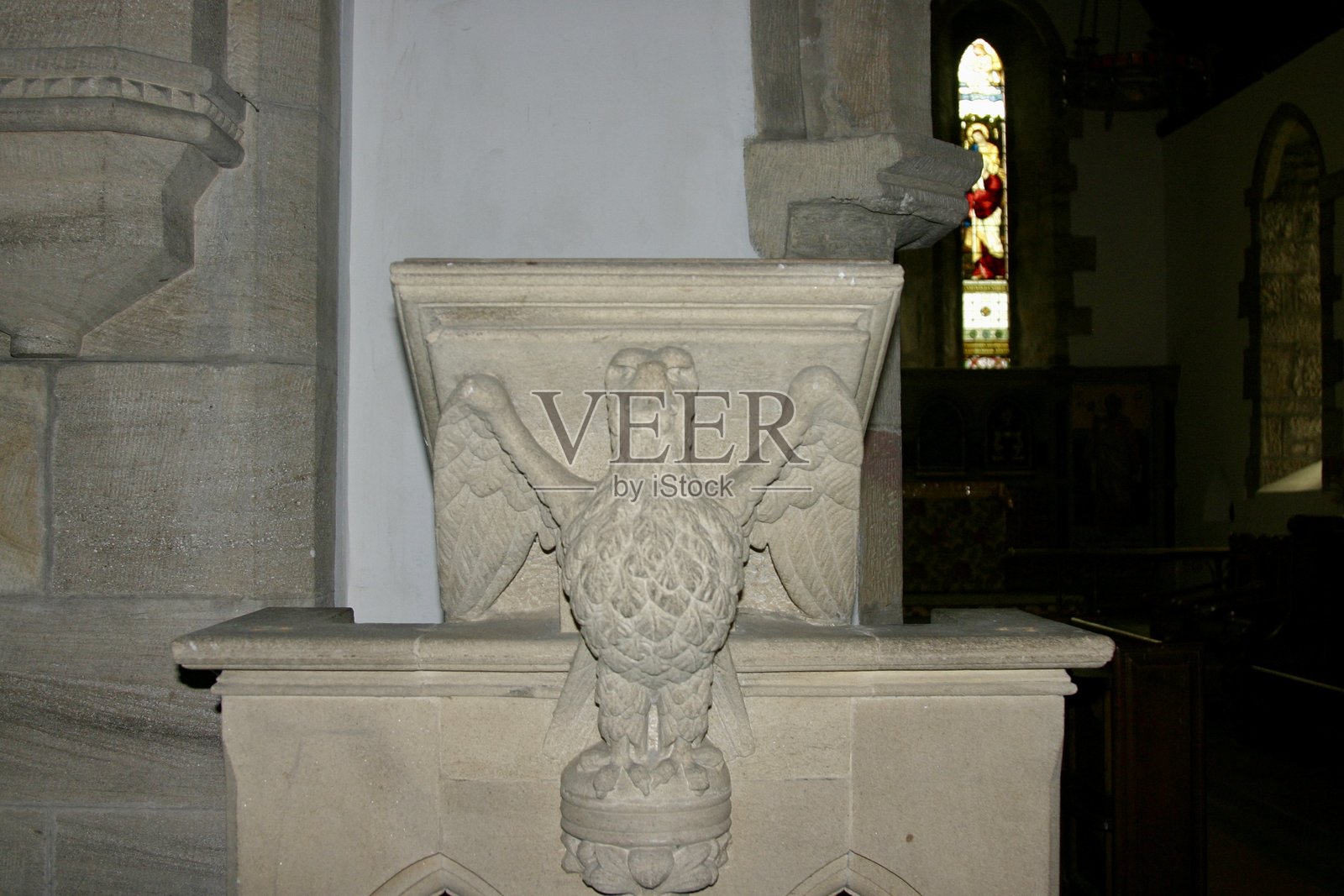 雕刻石制讲台,饰有鹰,通常象征圣约翰福音书作者,通常在教堂中发现。哥特式建筑细节,带有尖拱和强烈的宗教风格。照片摄影图片