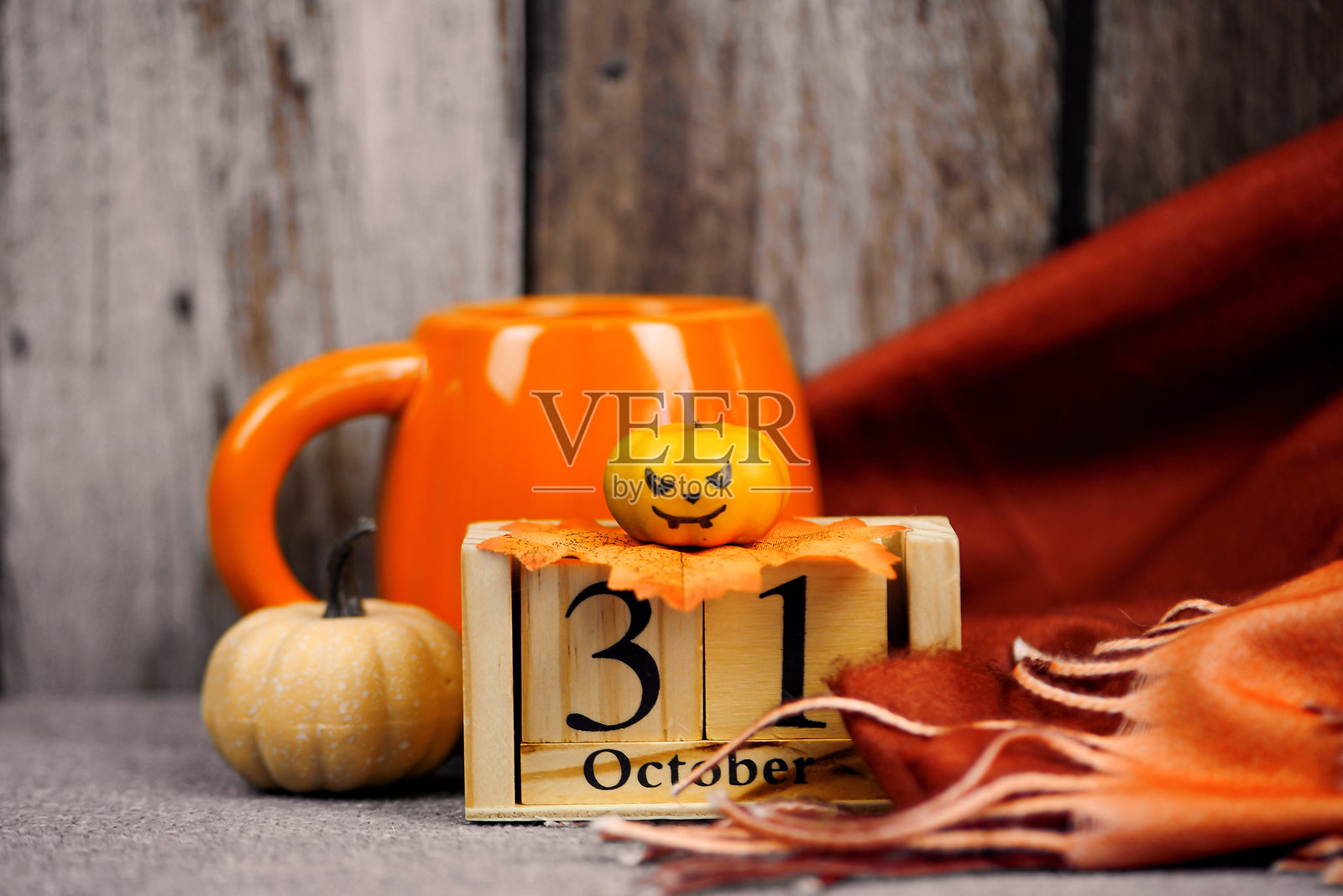 带有秋季装饰的咖啡杯和木质日历的万圣节概念照片摄影图片