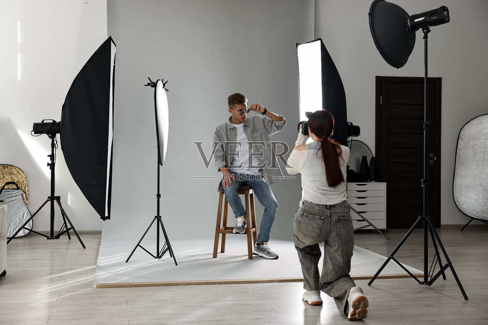 摄影师在专业摄影工作室与模特合作照片摄影图片