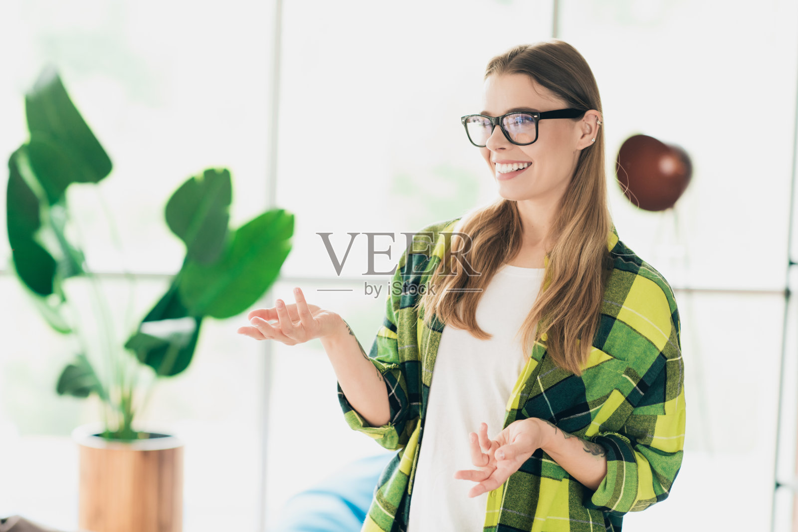 穿着休闲服的职业女性在现代室内空间中工作,面带温暖的微笑,风格时尚。照片摄影图片