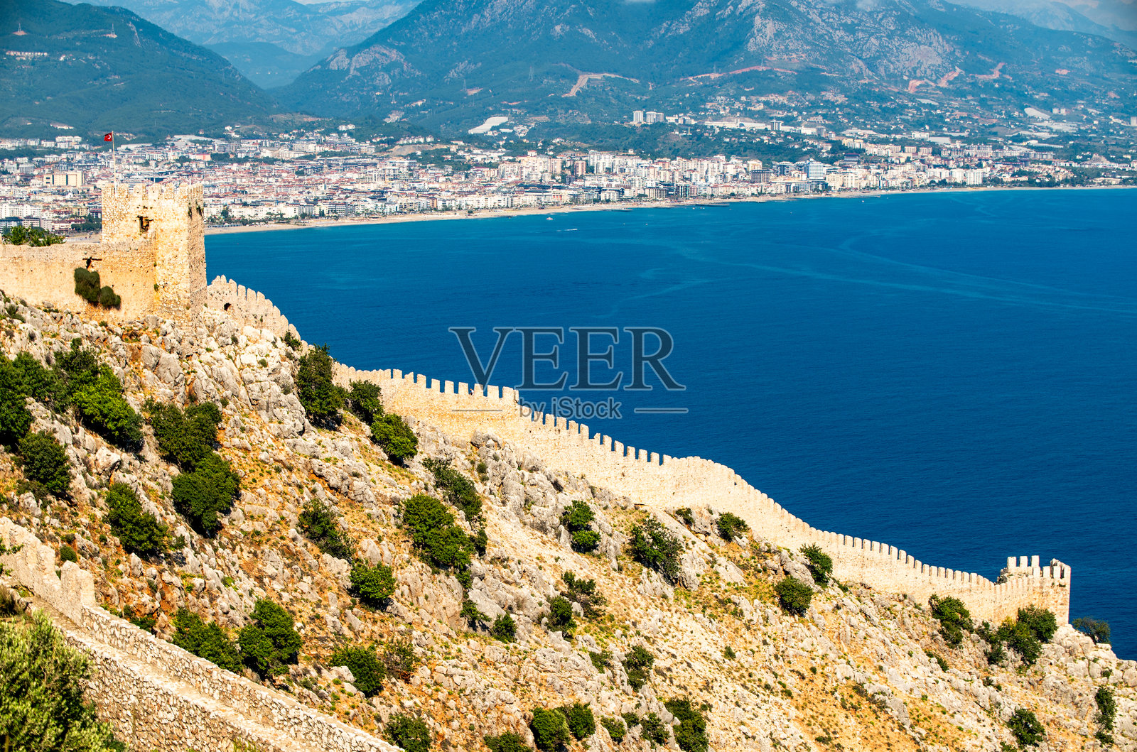 土耳其海岸悬崖上蜿蜒而下的中世纪城堡墙的广角视图照片摄影图片