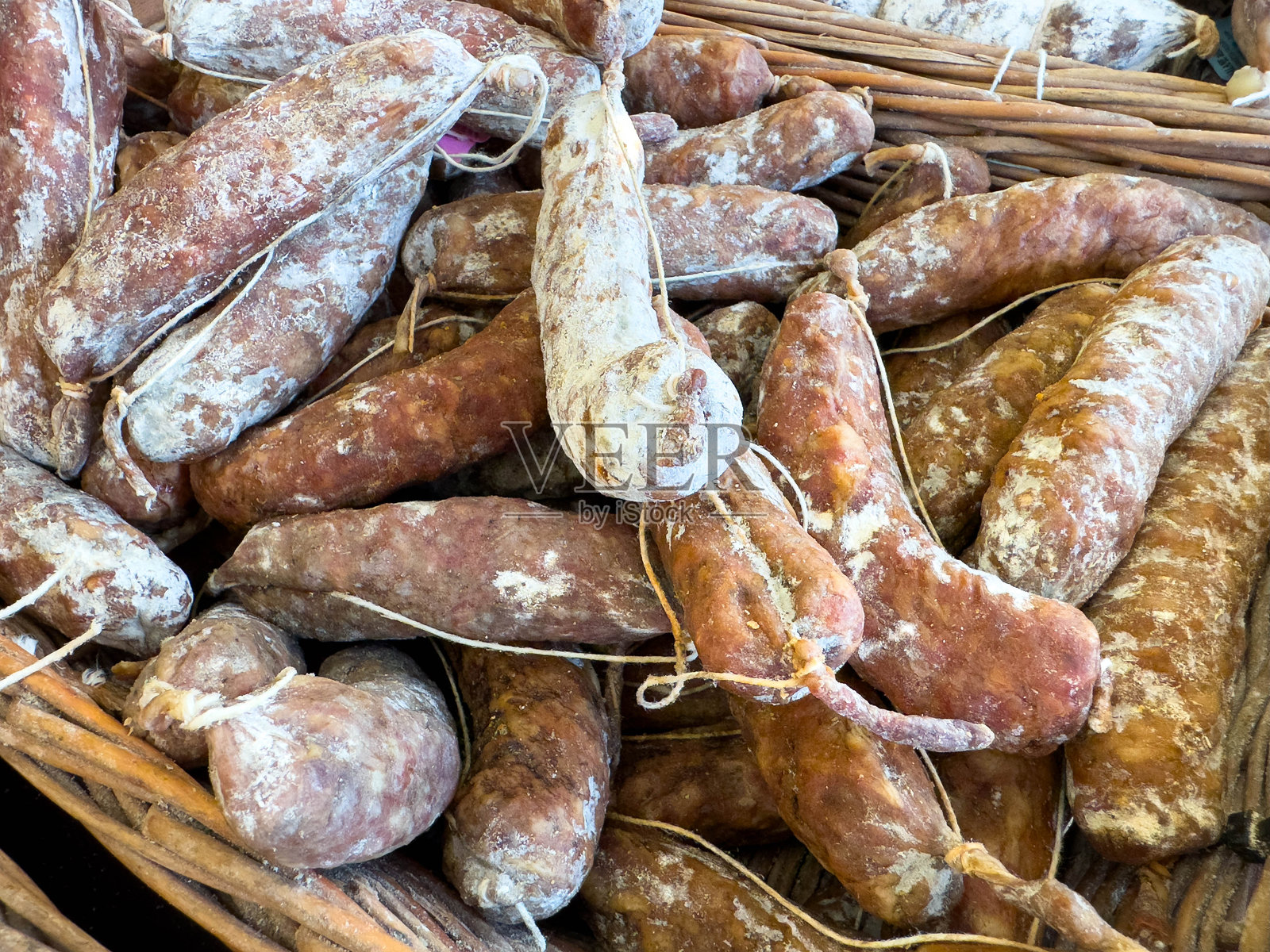 乡村风格的干腌香肠混合装在柳条篮中照片摄影图片