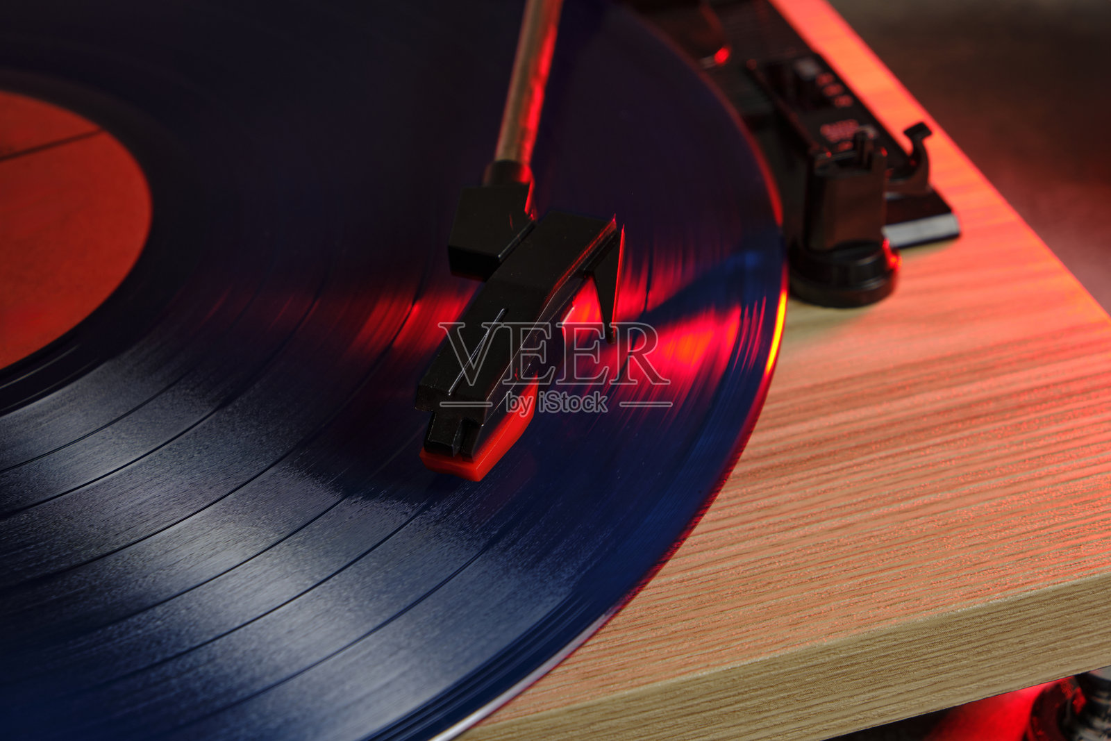 经典黑胶唱片播放器特写,带有轮廓红光。照片摄影图片
