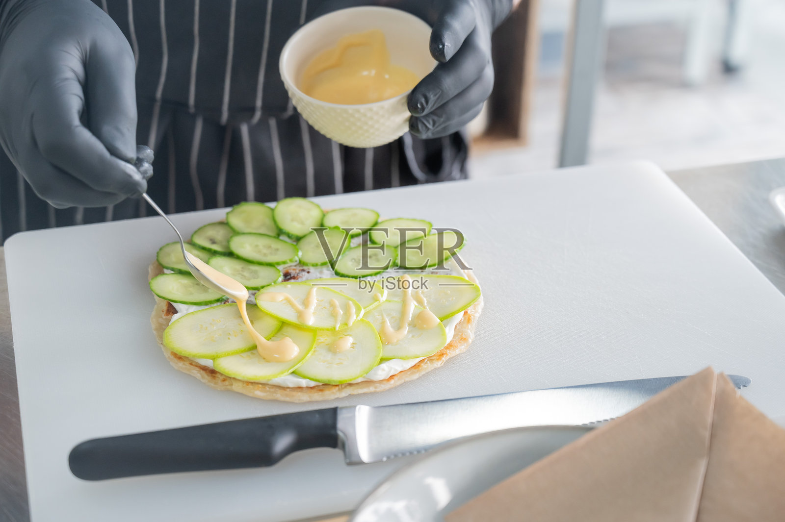 厨师正在准备一种带有香草的扁面包。照片摄影图片