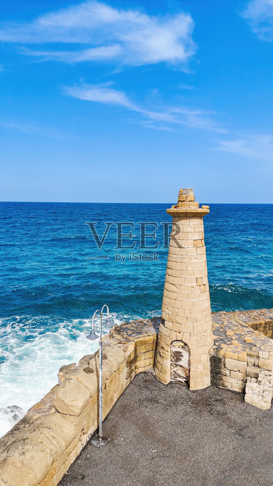 北塞浦路斯基尔尼亚港口入口处的古老石灯塔和防波堤的鸟瞰图,碧蓝的地中海和小型码头,海岸地标与旅行概念照片摄影图片